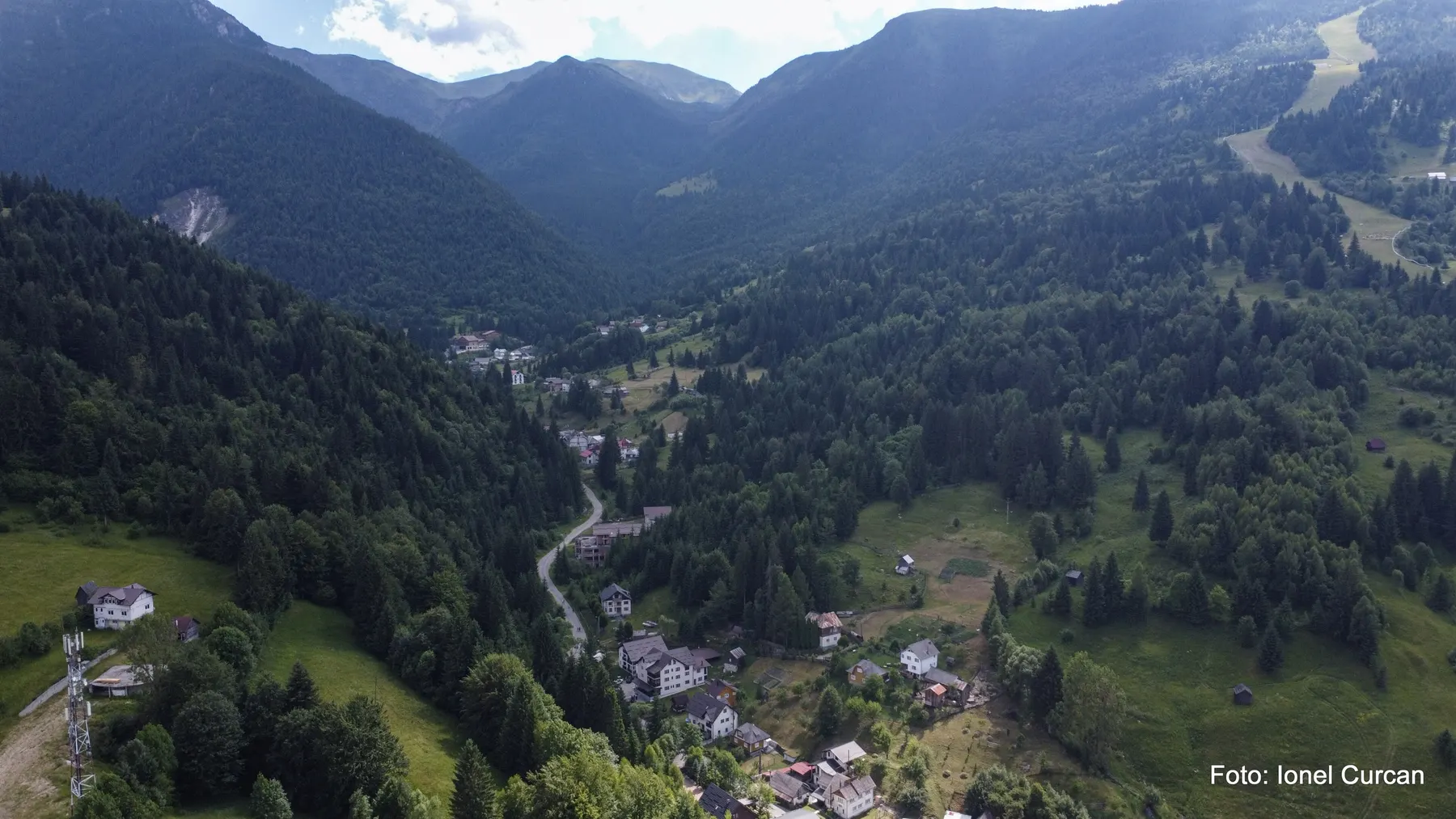 Stațiunea Borșa văzută de sus, cu pârtia de schi tăiată prin pădure, în dreapta.