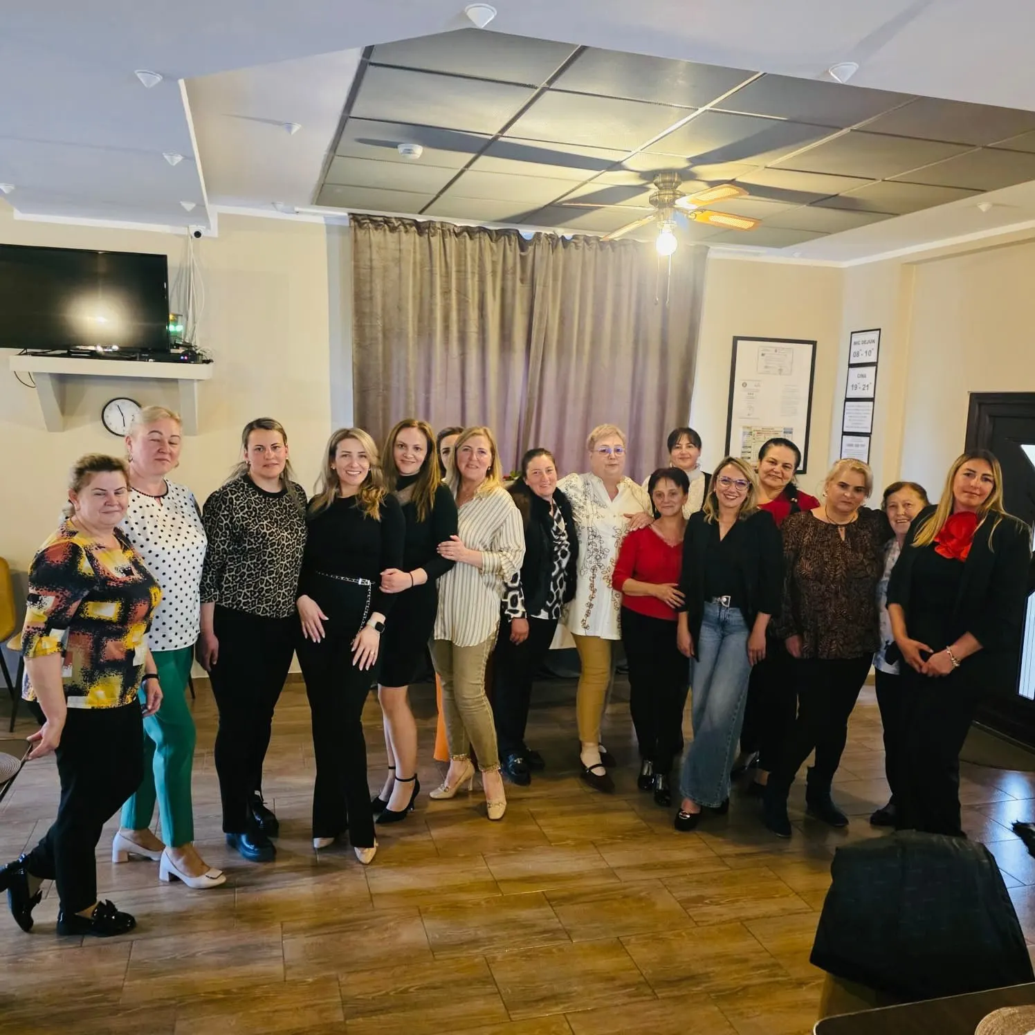 Grup de oaspeți fotografiați împreună în sala de mese.