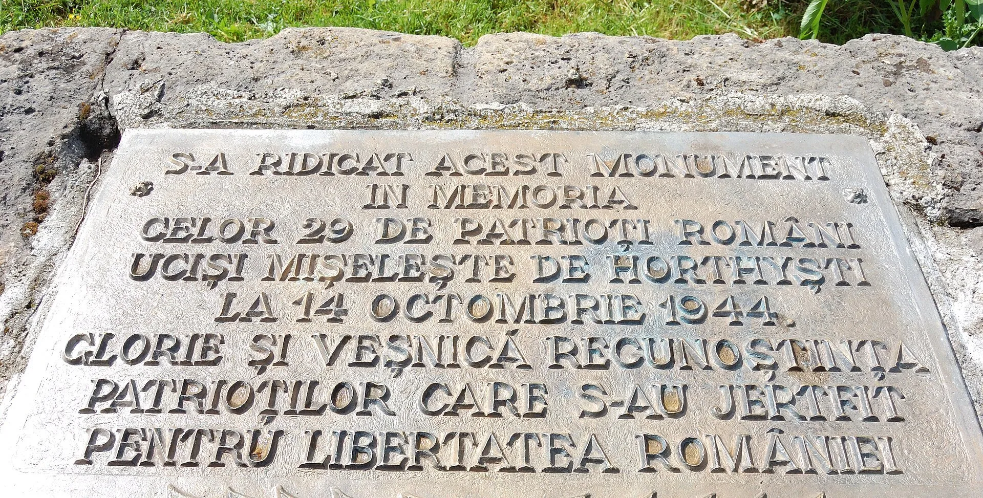 Placa de piatră a monumentului de la Moisei, cu inscripția despre cei 29 de români uciși la 14 octombrie 1944.