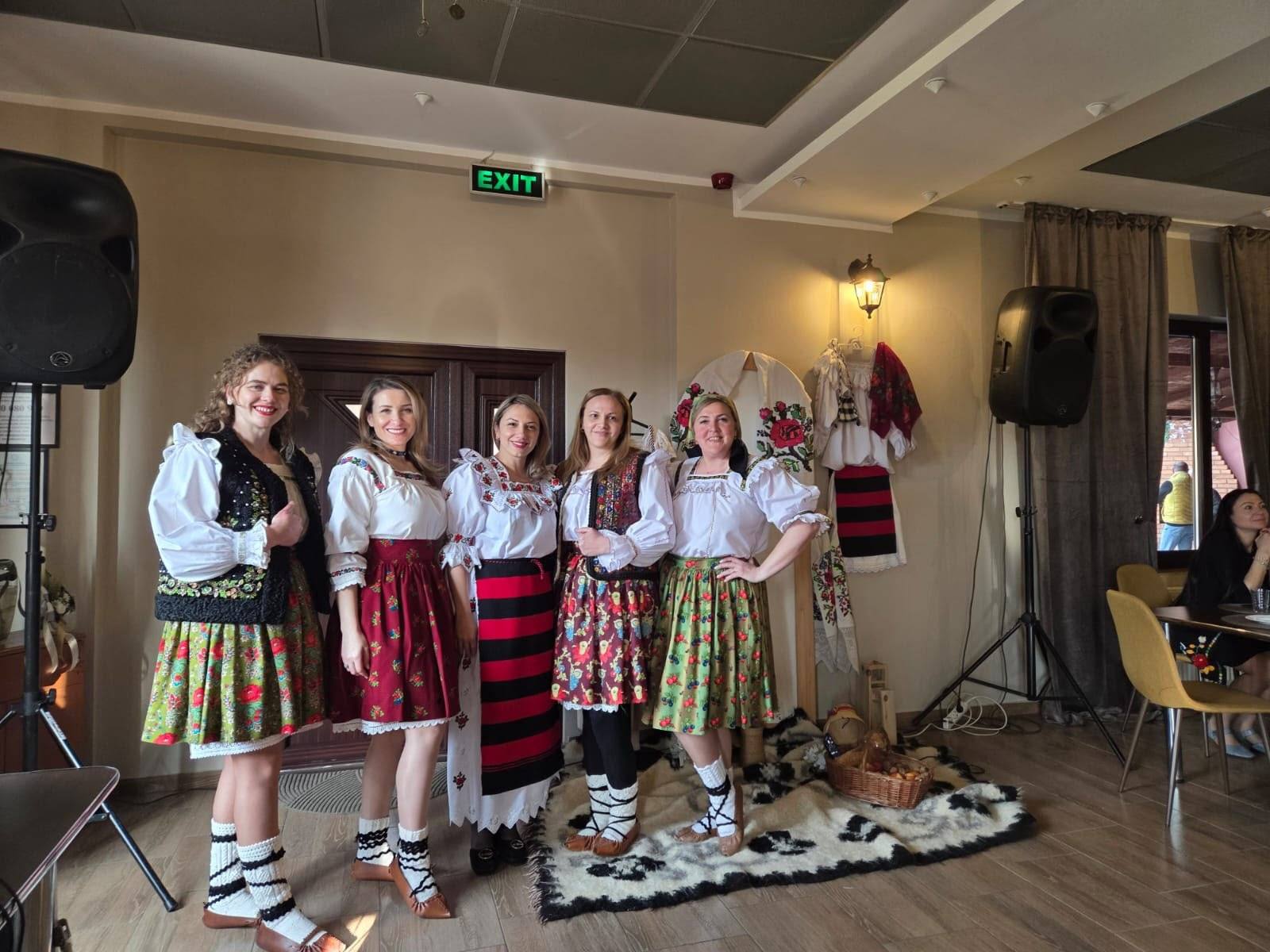 Grup de oaspete îmbrăcate în port popular maramureșean, în sala pensiunii.